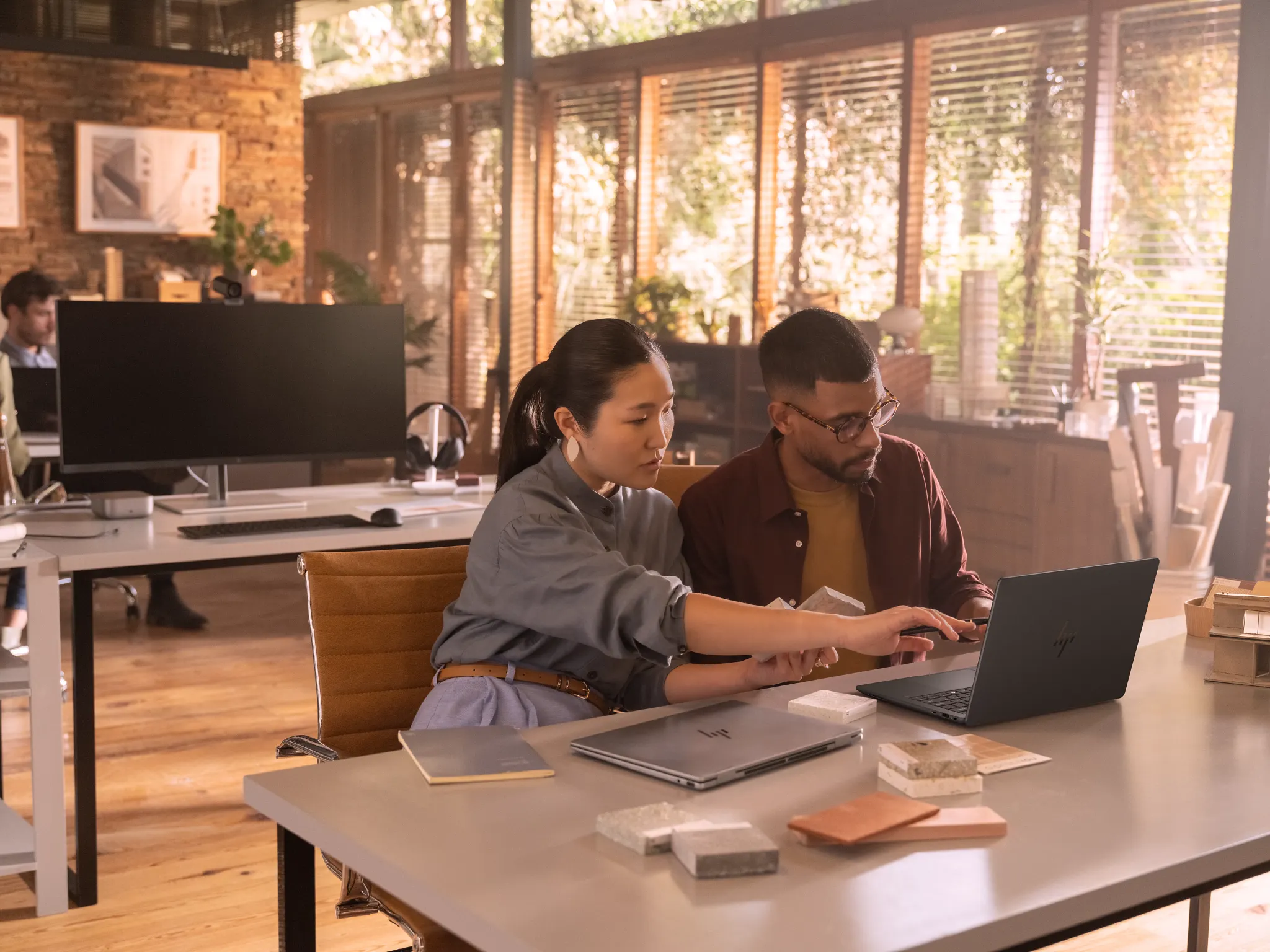 HP ZBook Ultra G1a: Eine Frau und ein Mann unterhalten sich am Schreibtisch